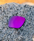 Apex Purple Non Polarized Replacement Lenses For Electric Stacker Sunglasses Made In Usa on a textured rock surface.