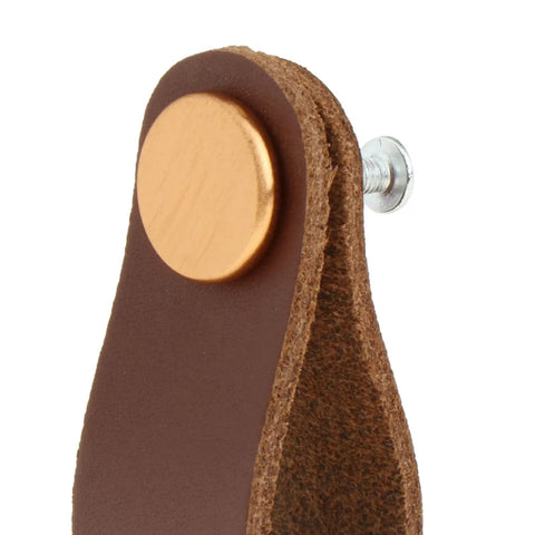 Close-up of leather furniture handle pull with screws for cabinets and doors brown leather cabinet knob hardware detail view