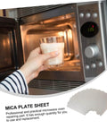 Woman using microwave with six piece microwave mica sheet waveguide cover set for ovens, heat resistant insulation mats shown