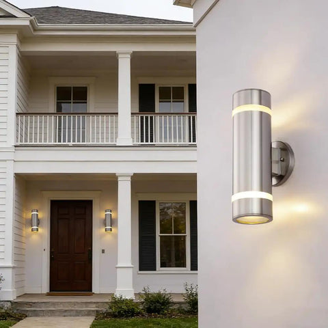 Dope Modern Cylinder Outdoor Wall Light Stainless Steel Porch Sconce With Nickel Finish, mounted on house entrance, glowing.