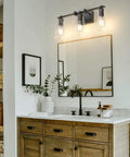 Vintage Industrial 3 Light Vanity Sconce In Black With Bubble Glass Shades above a wooden bathroom vanity.