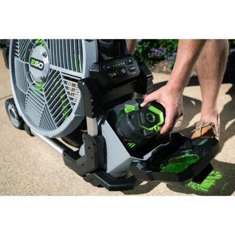 Person inserting battery into Go To Outdoor Mist Cooling Fan With 18 Inch Blade, 5 Speed Settings, Delivers Up To 5,000 CFM, Two Misting Modes.