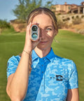 Person using V6 Shift Laser Rangefinder With Slope Compensation And PinSeeker, posing on a golf course.