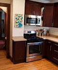 Modern kitchen with dark wood cabinets featuring 12mm Diameter Brushed Stainless Steel T Bar Cabinet Handles Hollow Pulls 8 Inch Overall Length.