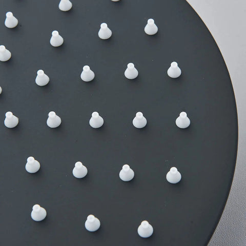 Close-up of matte black 8-inch round shower head with white nozzles from Matte Black Shower System With 8 Inch Round Shower Head And Handheld Spray Brass Rough In Valve Durable Stainless Steel Hose And Complete Trim Kit For No Fuss Installation.