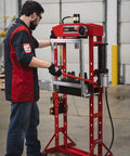 Technician operating a 20 Ton Hydraulic Shop Press With Dual Air Motor And 7 Position Bed Height Polycarbonate Shield in workshop.