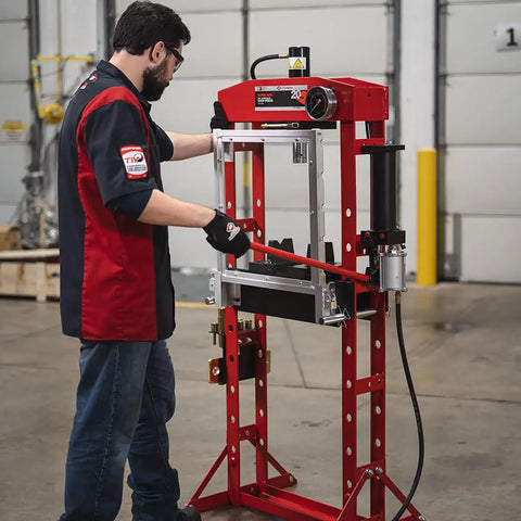 Technician operating a 20 Ton Hydraulic Shop Press With Dual Air Motor And 7 Position Bed Height Polycarbonate Shield in workshop.