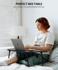 Person using Foldable Laptop Bed Desk With Cup Holder, Tablet Slot And Lifting Handle, Portable Lap Table for work on bed