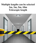 Wall mounted Heavy Duty 10 Meter Retractable Belt Barrier for security in a hallway, featuring yellow and black nylon ribbon.