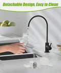 Detachable design easy to clean kitchen faucet pouring water into jar with black handle and bowl of apples in background.