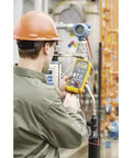 Technician using Slick One Hand Electric Pressure Calibrator for precision pressure checks in an industrial setting.