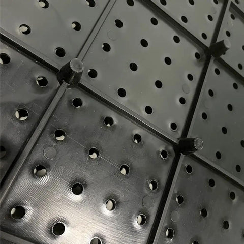 Close-up view of Black Plastic Pegboard Wall Organizer Panels, 4 Pack of 17.5x17.5 Inches, showing stand-off design and holes.