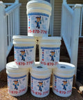 Image of five buckets of Superior Exteriors Cleaning Company cleaning products stacked on gravel.