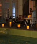 Lit 10 Inch Outdoor Flameless Candles With Remote And Timer on porch, glowing in lanterns by poolside, weatherproof, set of 2