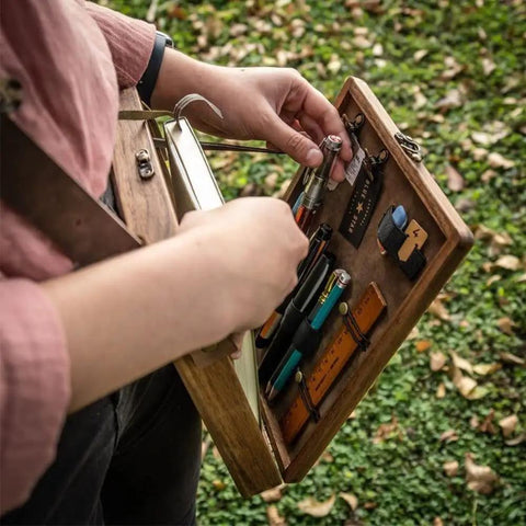 Person using Wooden Messenger Box Crossbody Bag For Artists Grab And Go Multifunctional Handmade Tool Storage Box Painting Brush Organizer Sketch Box And Portable Easel Case For Outdoor Painting Brown