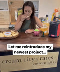 A woman tasting chips at a wooden counter with snacks and drinks, promoting Cream City Crates custom gifts.