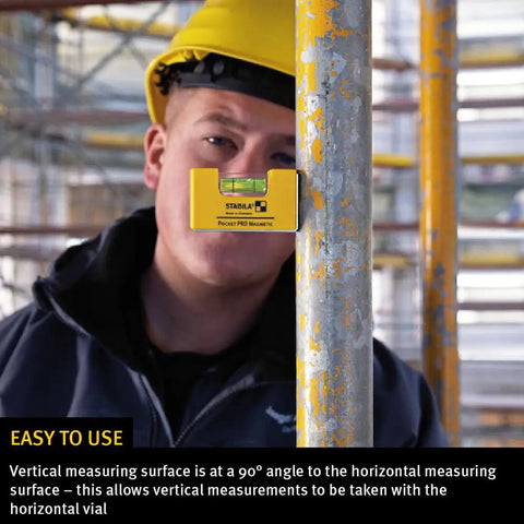 Construction worker using Magnetic Pocket Level Pro for quick adjustments on scaffolding pole.