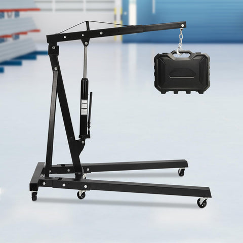 Folding Hydraulic Engine Hoist Cherry Picker 2 Ton lifting a case, featuring heavy duty carbon steel and six wheel rig design.