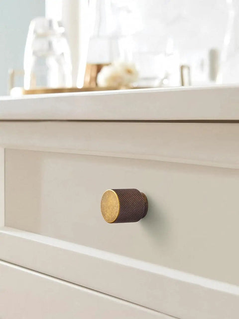 Single 6 Pack Antique Brass Cabinet Knob Set With Zinc Alloy Construction on white drawer front.