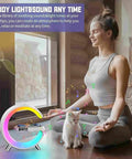Woman meditating with Bluetooth Speaker Lamp With Wireless Charger And App Control, RGB Night Light, Alarm Clock, and a cat.