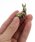 Hand holding Solid Brass Rabbit Cabinet Pull Set With Vintage Brass Knobs Antique Finish Drawer Pulls for kitchen cabinets