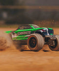 1/18 Scale Granite GROM Mega 380 Brushed 4x4 Monster Truck RTR kicks up dirt in off-road action, green body visible