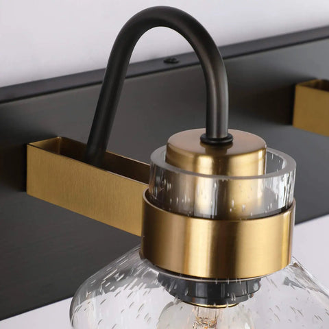 Close-up of black and brushed gold farmhouse style over mirror wall sconces with bubble glass from Two Light Bathroom Vanity Lighting Fixture.