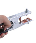 Hand holding a multifunction 500A ground clamp with ergonomic grip for TIG plasma cutting and stable connections.