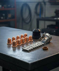 Pro Grade Torch Consumables Kit With Cutter Nozzles Electrodes Retaining Cap Insulating Cap And Washers, Heavy Duty Spare Parts For Fabrication Shops, Repair Garages, And Home Workshops; copper nozzles and silver electrodes on bench