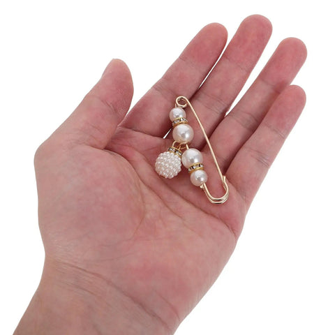 Pearl pin style waist tightening clip held in hand, ideal for jeans and dresses, delivering a snug custom fit.