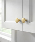 Close-up of Brushed Brass Gold Mushroom Cabinet Knobs Set 25 Pack Zinc Alloy Drawer Handles on white cabinet doors.