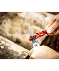3 1/4 Inch Drop Point Pocket Knife With Aluminum Handle, cutting rope outdoors, showcasing ergonomic grip and D2 Steel Blade.