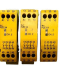 Industrial Safety Relay 24V DC Control Unit With Four Normally Open Solid State Outputs For Emergency Stop Circuits And Safety Gates In Automated Factory Settings. Yellow control unit featuring four outputs and labeled connections.