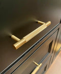 Four Pack 3 Inch Solid Brass Cabinet Pulls In Brushed Gold Finish for Kitchen Cabinets and Drawers installed on dark wood cabinetry.