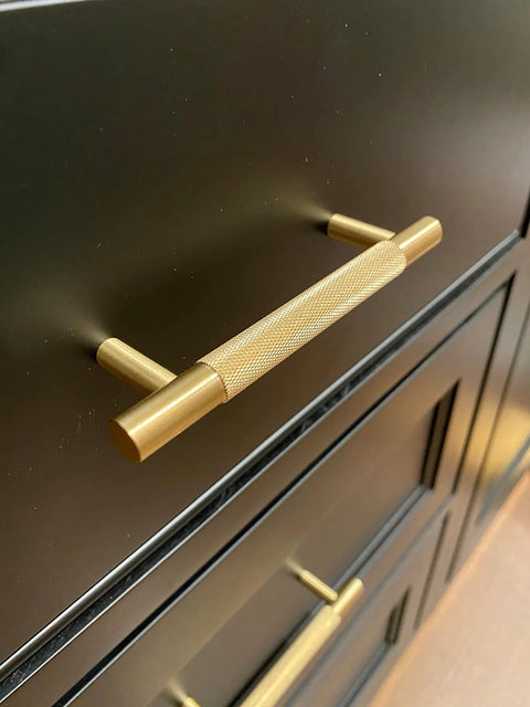 Four Pack 3 Inch Solid Brass Cabinet Pulls In Brushed Gold Finish for Kitchen Cabinets and Drawers installed on dark wood cabinetry.