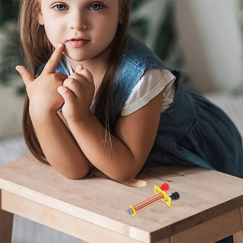 Child near Two Pack T Shaped Solenoid Electromagnet Coil Kit For Hands On Physics Experiments on a wooden table