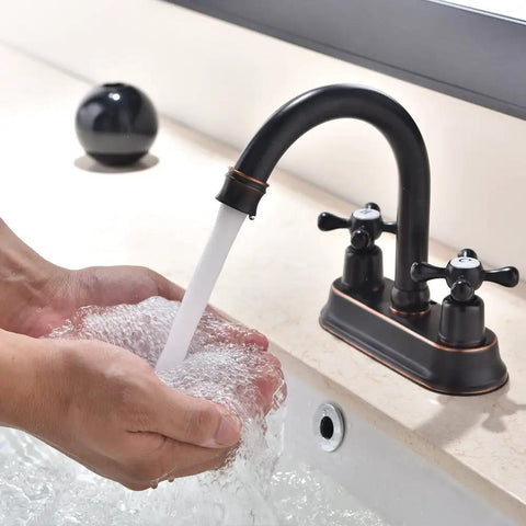 Person washing hands with water from Oil Rubbed Bronze Bathroom Faucet With 2 Handles 4 Inch Centerset Vanity Sink Faucet Stainless Steel Farmhouse Deck Mount Lavatory Mixer Tap For RV And Home