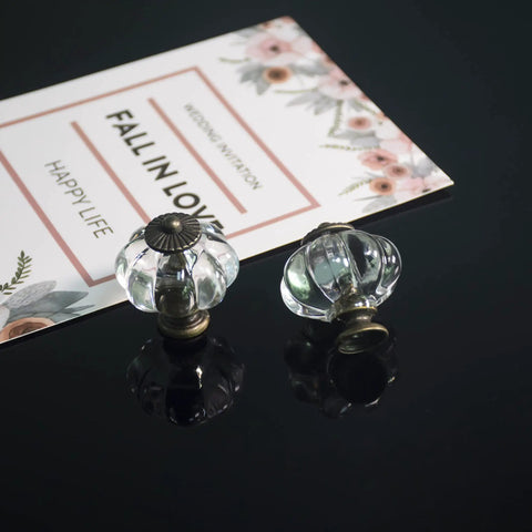 Two Clear Acrylic Pumpkin Cabinet Knobs from Set Of 20 Vintage Decorative Pulls for Doors, Drawers, and Furniture on Black Surface