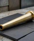 Top Tier Heavy Duty Brass Fire Nozzle 1.5 Inch NST fitting lying on slate surface, durable for firefighting use.