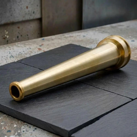 Top Tier Heavy Duty Brass Fire Nozzle 1.5 Inch NST fitting lying on slate surface, durable for firefighting use.