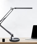 LED Desk Lamp With Clamp And Round Base Go To Swing Arm Eye Caring Table Light Three Color Modes Ten Brightness Levels Memory Function USB Powered 14W Office Desk Lamp Black on desk next to laptop