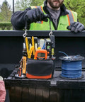 Tradesman Pro Tool Pouch with Electrical Tape Thong and Reinforced Bottom held by person on work site