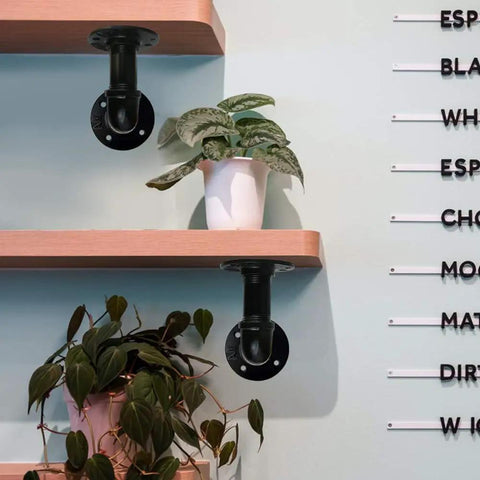 Wall-mounted DIY shelving with Six Pack 1 Inch Steel Pipe Two Inches Long Black Industrial Pipe Set For Home Decor.
