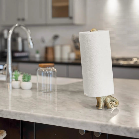 Totally Gold Dino Paper Towel Holder Stand for Kitchen and Bathroom Decor, metal free standing roll holder on marble countertop.