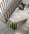 Level Up Your Space With This Rock Solid Wrought Iron Railing Kit Featuring Square Metal Spindles Heavy Duty Side Mount Brackets Fasteners Ideal For Porches And Deck Railings, shown on modern staircase.