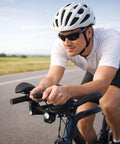 Cyclist using Triathlon T Handlebar Aerobars For Road Bikes With Beefy Aluminum Alloy Build Rest Pads And Cushions on open road