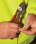 Person using USA Made Wire Cutter, Stripper, and Crimp Tool With Shear Cutter on electrical wire, close-up of tool in hand.