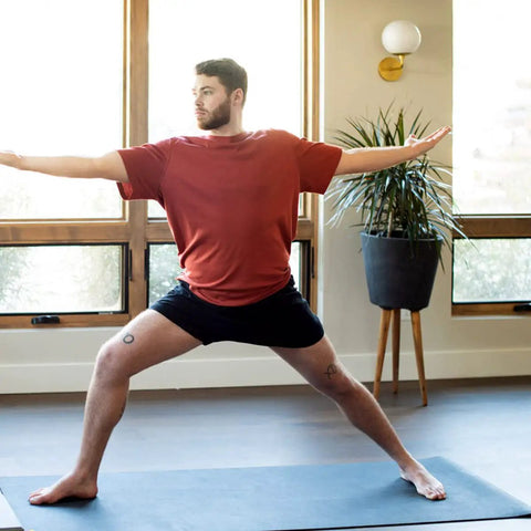 Person practicing yoga on XL Rubber Yoga Mat 78 Inch By 28 Inch Storm Color With Dual Sided Non Slip Grip Roomy One Quarter Inch Thick Cushion Natural Sustainable Rubber Durable For Home Practice And Studio Flows And Deep Stretches in home setting.