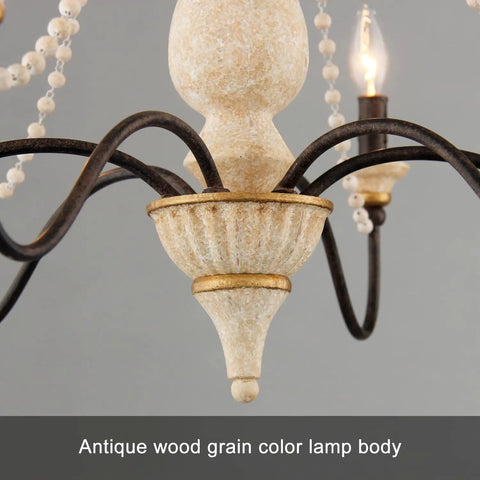 Close-up of distressed white wood finish on French Country Farmhouse Six Light Chandelier with wood bead accents for cozy homes.
