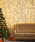 300 LED Fairy Curtain Lights USB Plug In 9.8 By 9.8 Feet Warm White With 8 Modes Indoor Outdoor Waterproof IP44 lights behind sofa and tree.